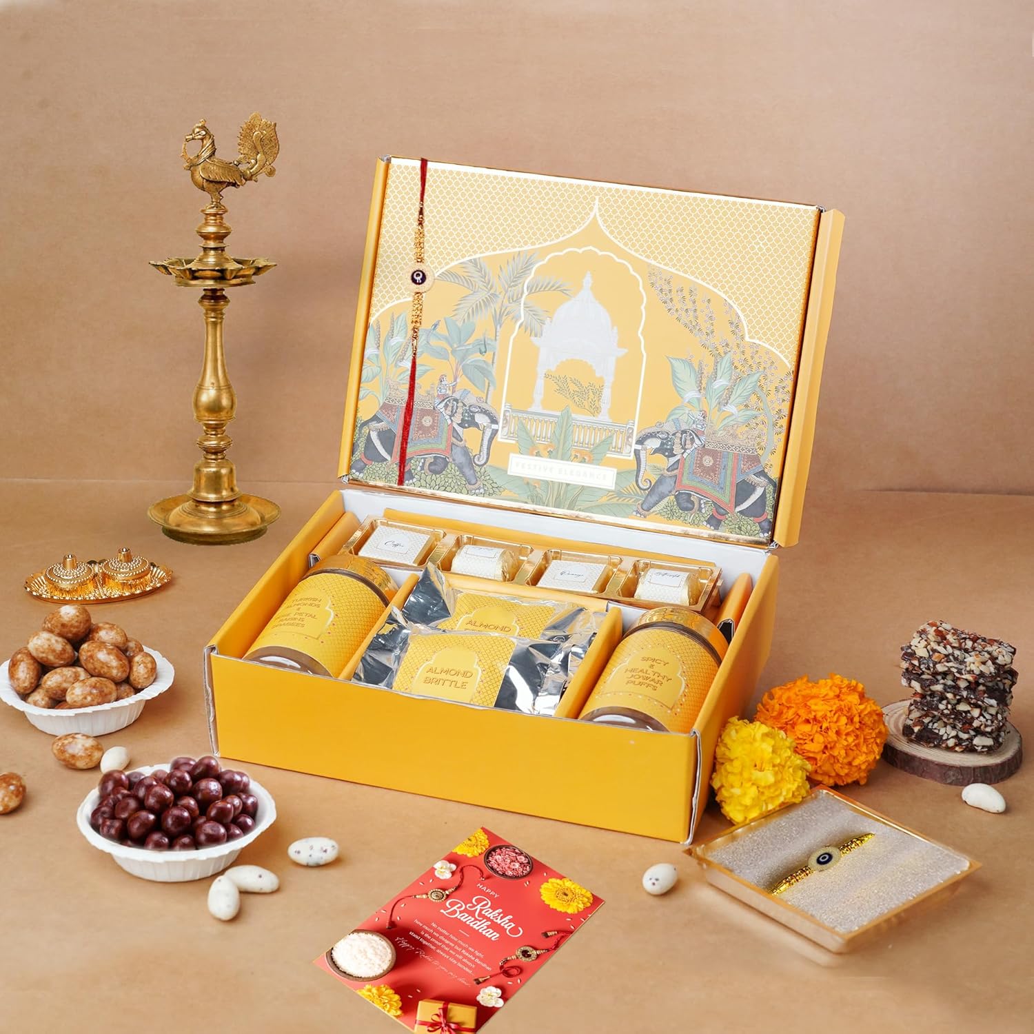 Oriole Gifts Rakhi Hamper for Brother with Premium Evil Eye Rakhi, Chocolate Bites, Almond Brittles, Coffee Almond Nutties, Paan Shots, Snacks & Greeting Card | Rakshabandhan Gift for Brother with Chocolate Gift Box - Image 2